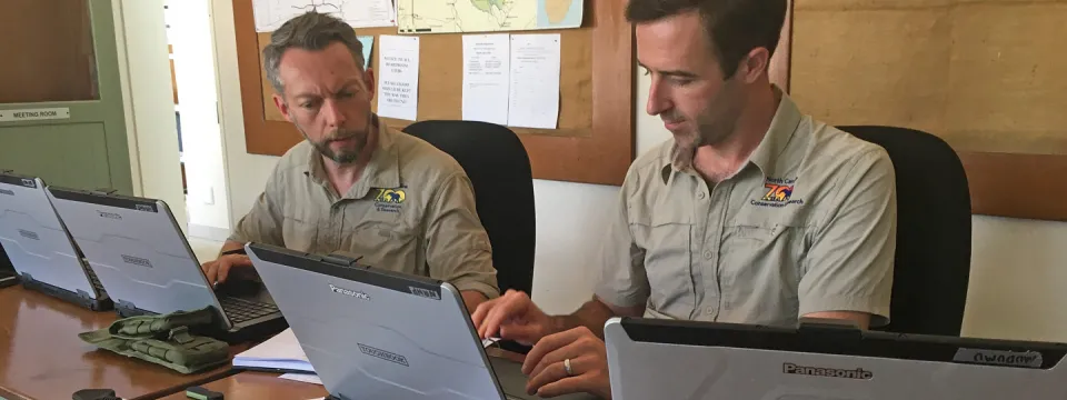 Two Zoo staff working at laptop computers