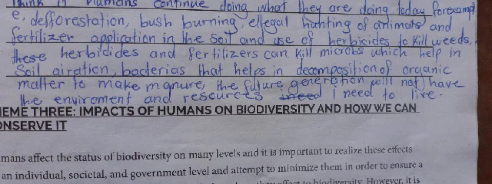 A handwritten response discusses the negative future environmental impact of deforestation, burning, illegal hunting, and the use of fertilizers and herbicides, noting their harm to soil microbes essential for healthy soil. Below this is a printed heading about the impacts of humans on biodiversity and conservation.