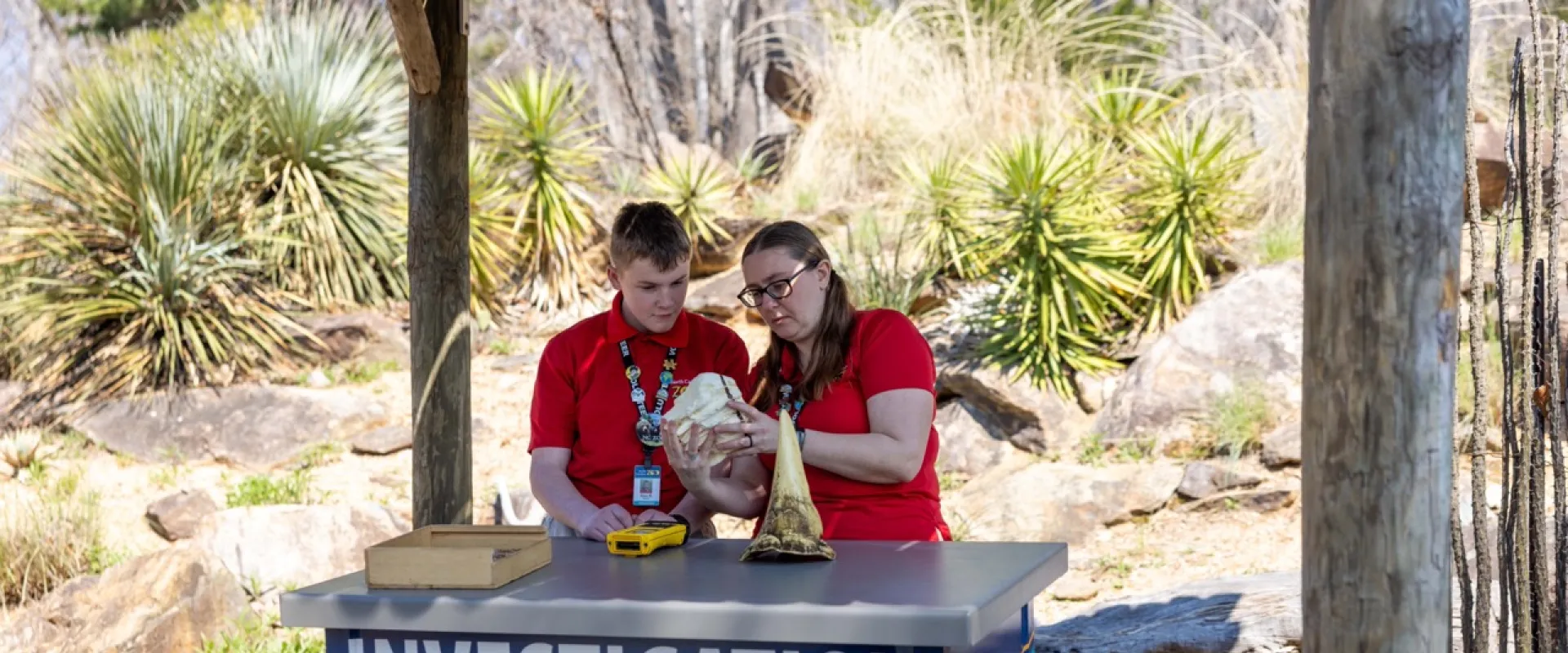 Mother and Son working an investigation station on a bright sunny day.