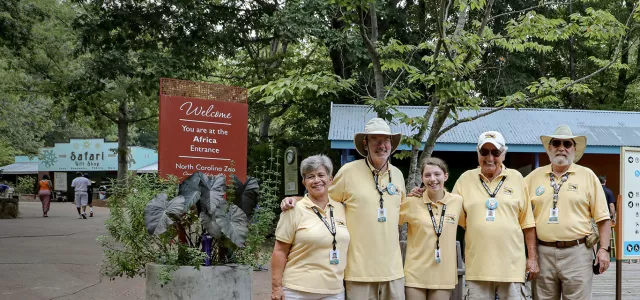 Five Zoo volunteers posing for the camera in Africa Plaza.