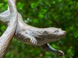 A bronze statue of several otters poised mid-frolic as they would be in the water.
