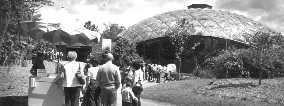 A black and white photo of guests entering the Zoo's aviary building. 