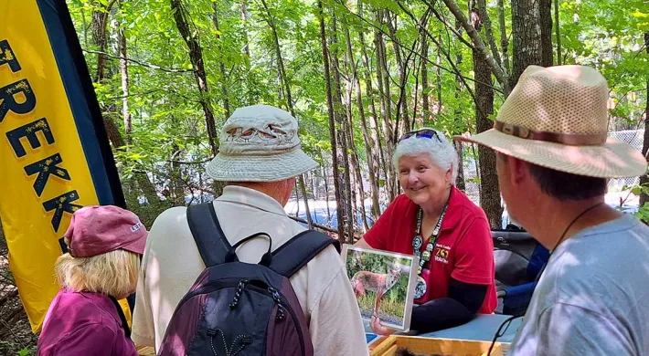 Volunteer talking to adults at Zoo Trekker cart at the Zoo