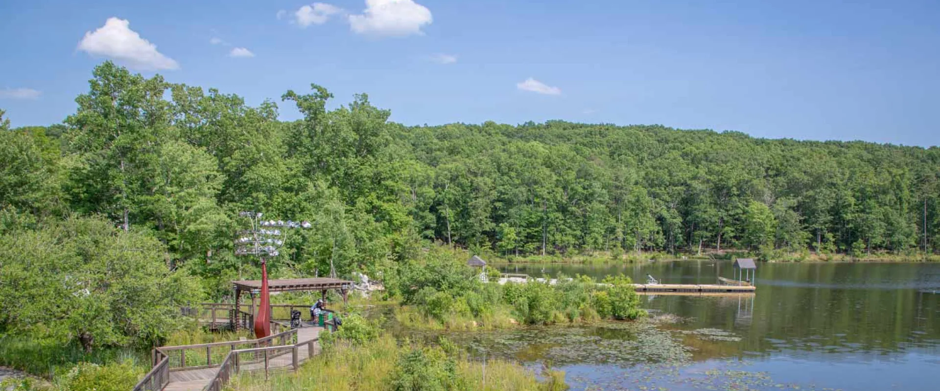 Lovely view from North America plaza of the lake, blue skies and a sculpture in the foreground.