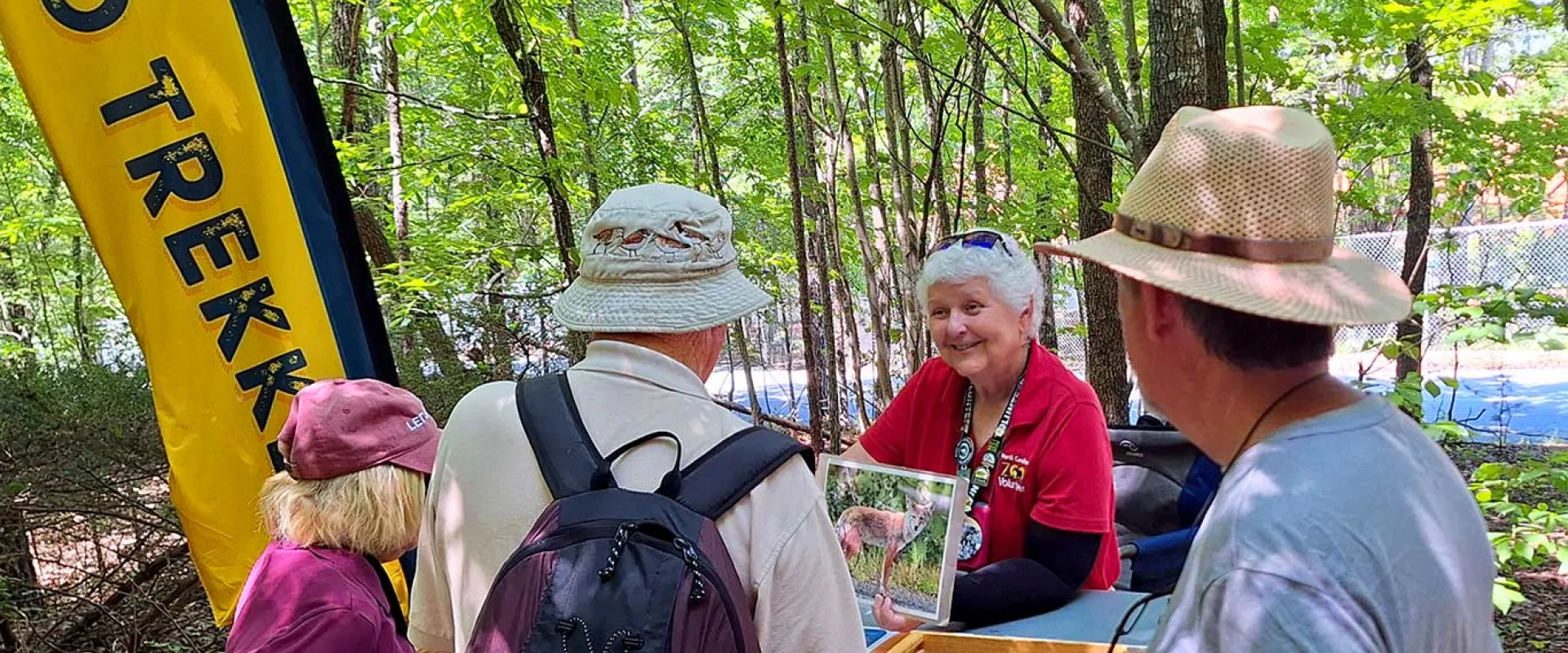 Volunteer talking to adults at Zoo Trekker cart at the Zoo