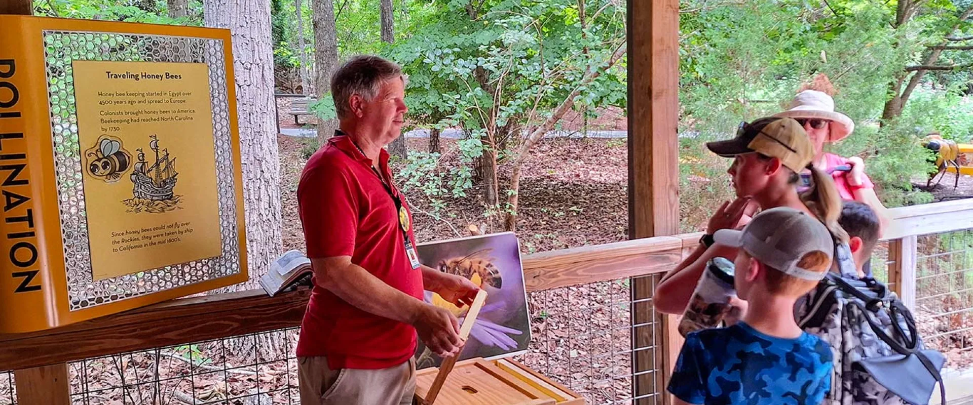 Volunteer talking with a group of guest at the Honey Bee habitat