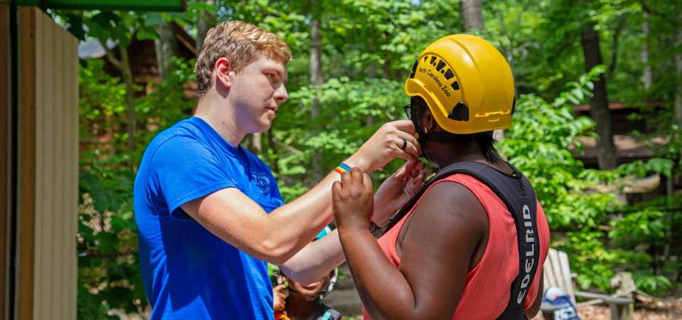 Seasonal staff helping get guests ready for Air Hike ropes course