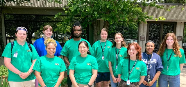 Group of ten Interns in standing in front of the Stedman Education center